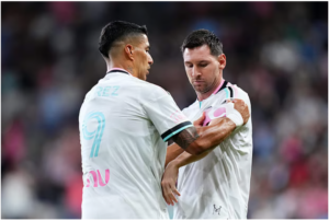 Luis Suarez binds the armband of Messi